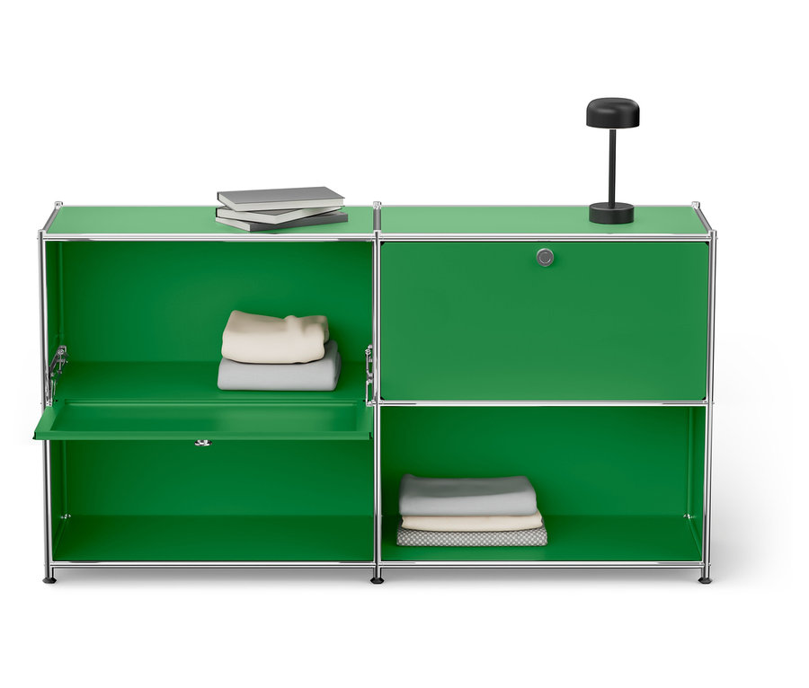 Zelená skrinka so strieborným rámom s dvoma policami a knihami, lampou a zloženým oblečením.