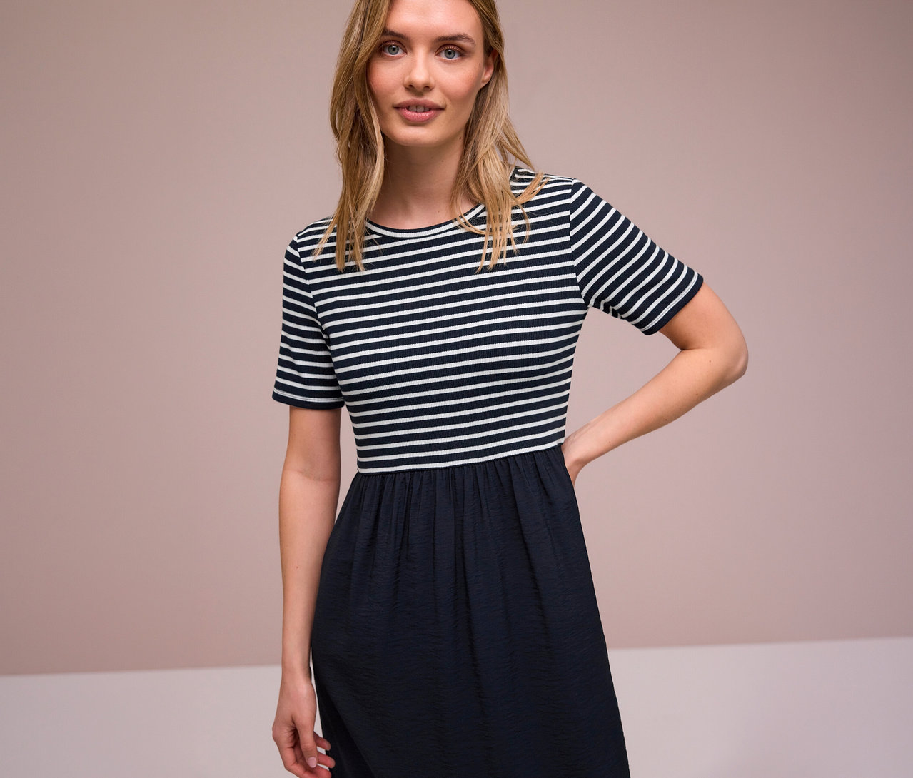 Žena v pruhovaných šatách Street One s krátkym rukávom a tmavou sukňou.