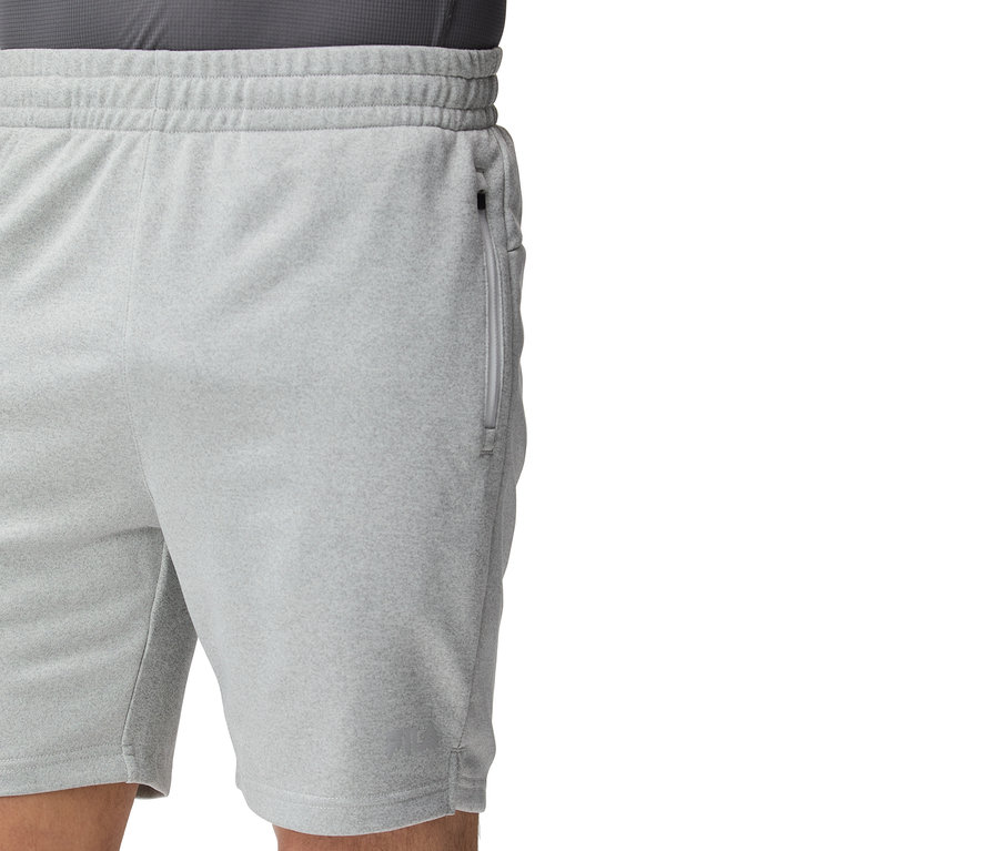 Detail záberu svetlosivých tréningových šortiek so zipsom na vrecku.