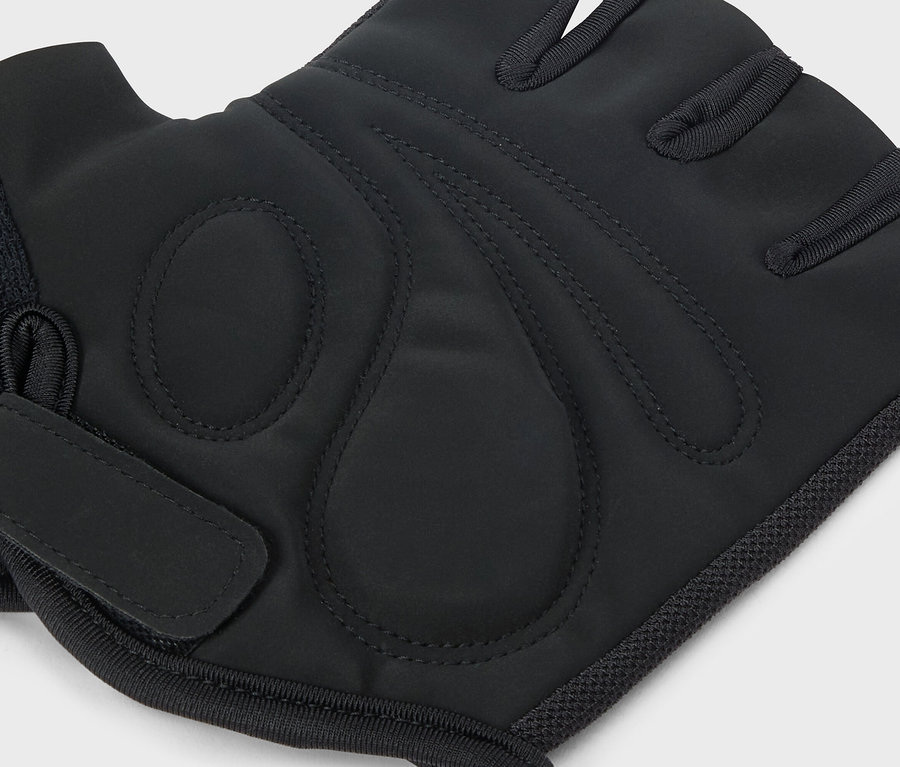 Detailný záber jednej čiernej tréningovej rukavice s pútkom na prsty na svetlosivom pozadí.