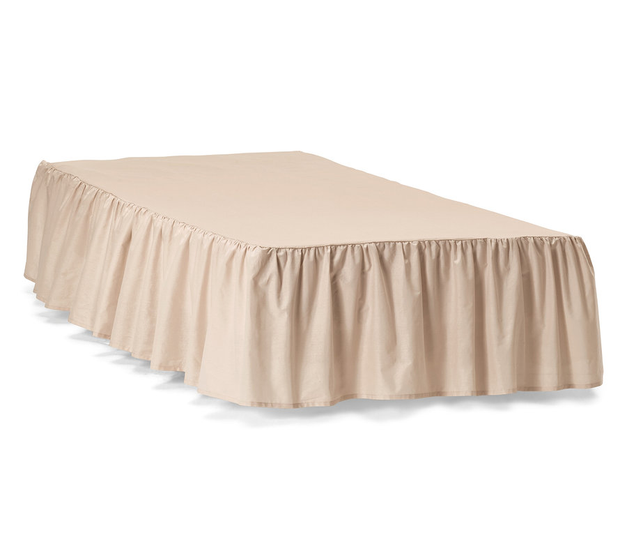 Béžová posteľná prikrývka s rozmermi cca 90 x 200 cm leží na posteli.