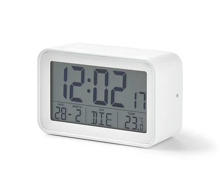 Biely digitálny LCD budík zobrazuje čas 12:02, dátum 28-2 a teplotu 23 stupňov Celzia.