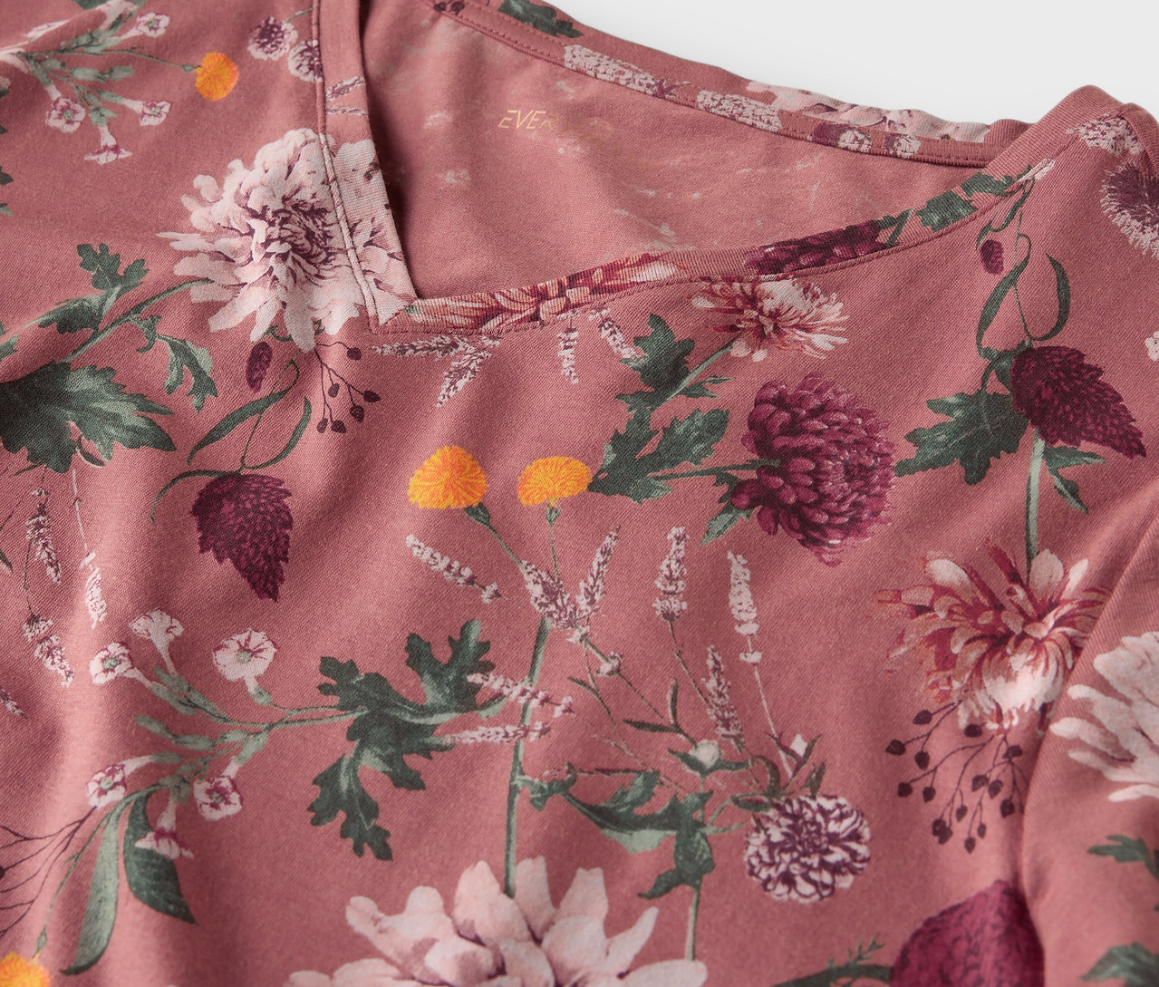 Detail ružového topu s kvetinovou potlačou.