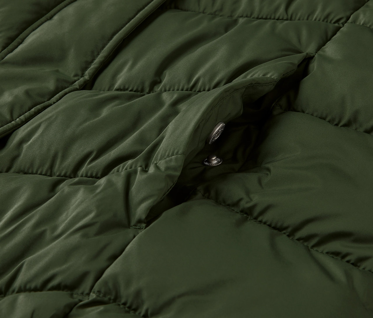Detailný pohľad na tmavozelenú prešívanú bundu Steppmantel mit Kapuze.