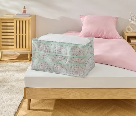 Na posteli leží Jumbo-Aufbewahrung.
