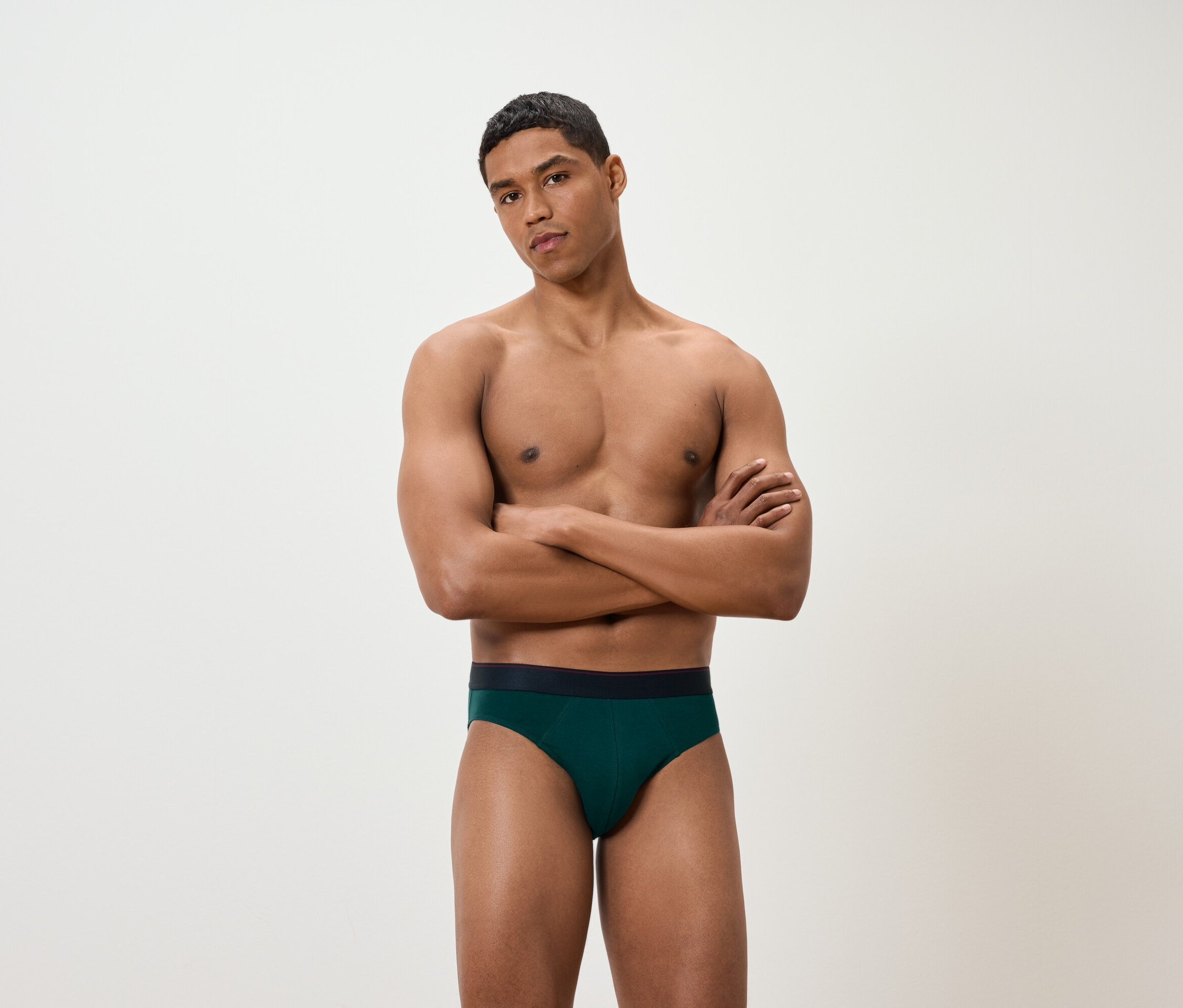 Muž so skríženými rukami má na sebe zelené slipy.