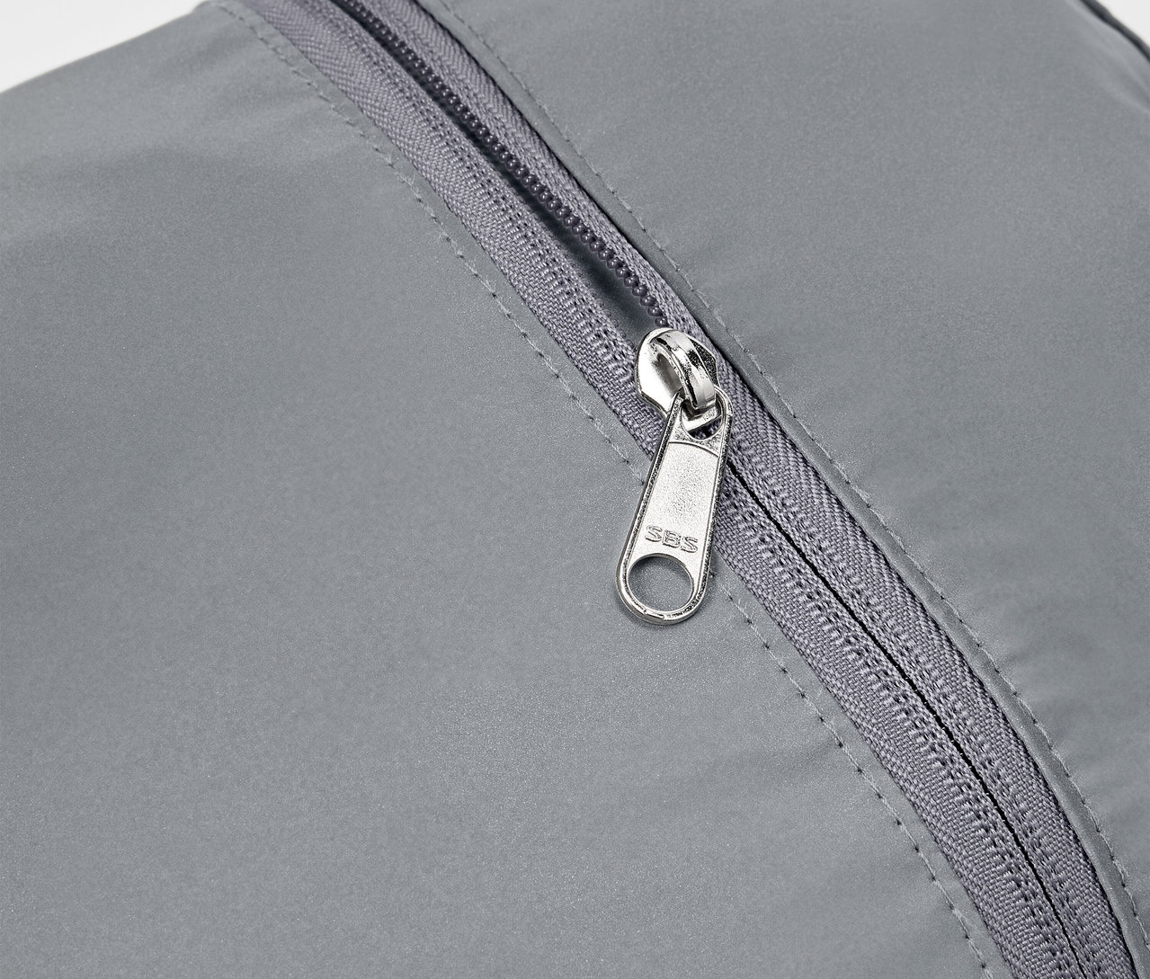 Detail šedého reflexného batohu so strieborným zipsom.