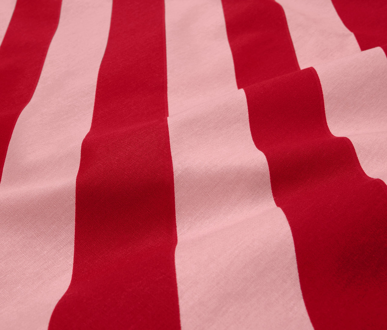 Detail červeno-bielej pruhovanej látky.