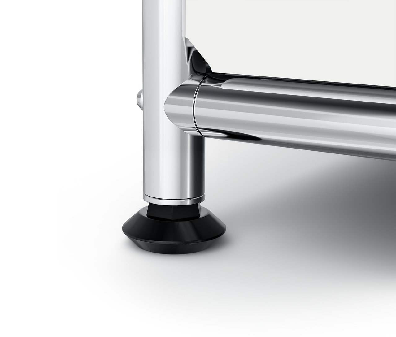 Detail chrómovej nohy nábytku s čiernou pätkou.