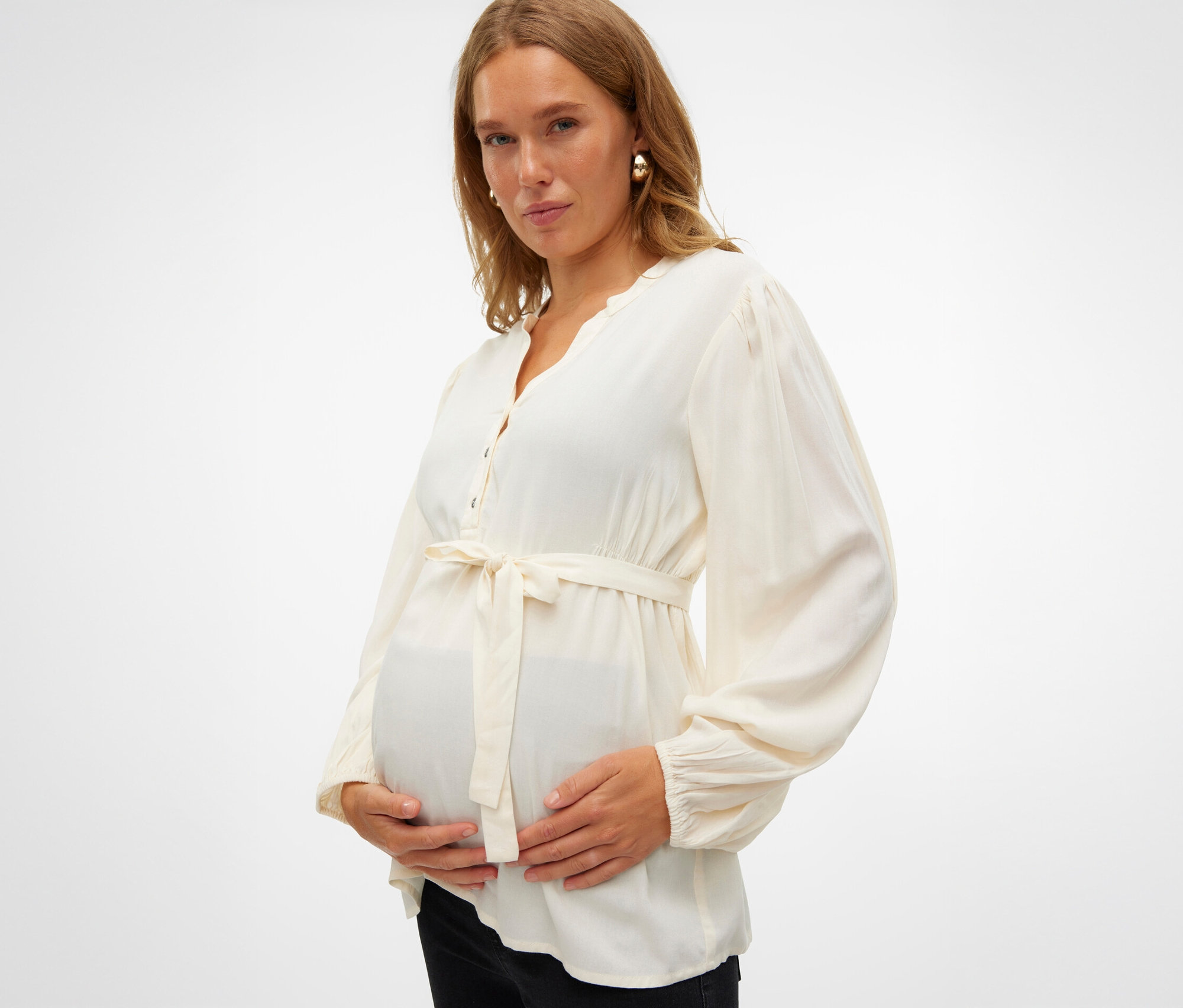 Tehotná žena drží si brucho a má na sebe MAMALICIOUS Top.