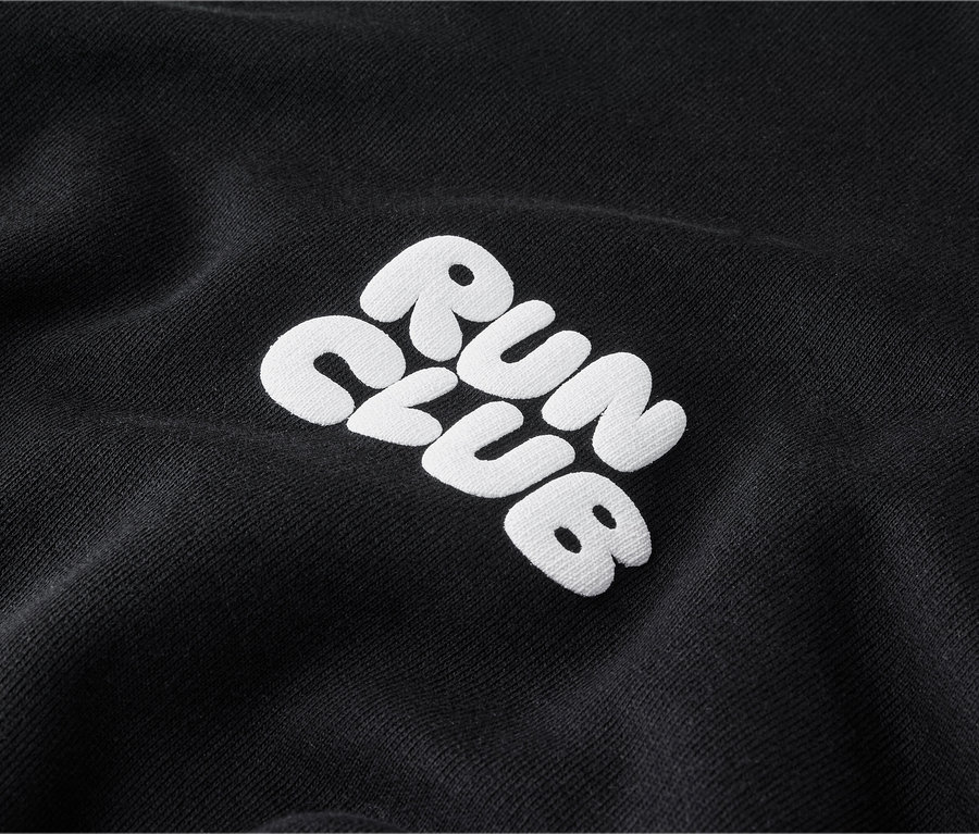 Detail čiernej mikiny s bielym vyšívaným nápisom „RUN CLUB“.