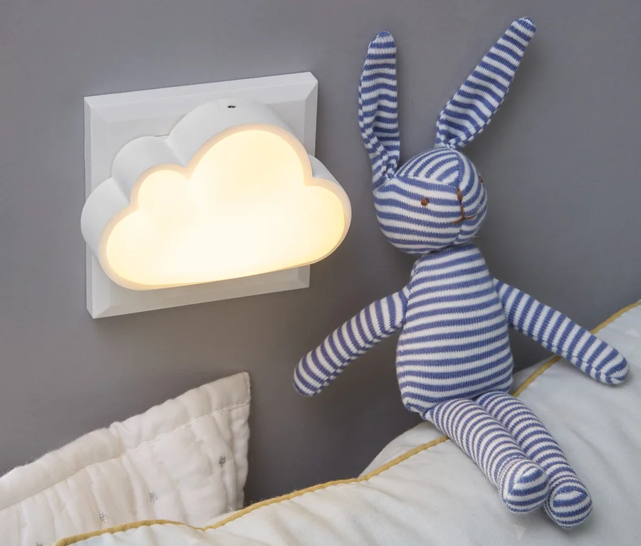 Na stene je namontované nočné svetlo s LED v tvare obláčika. Na vankúši sedí plyšový zajačik.