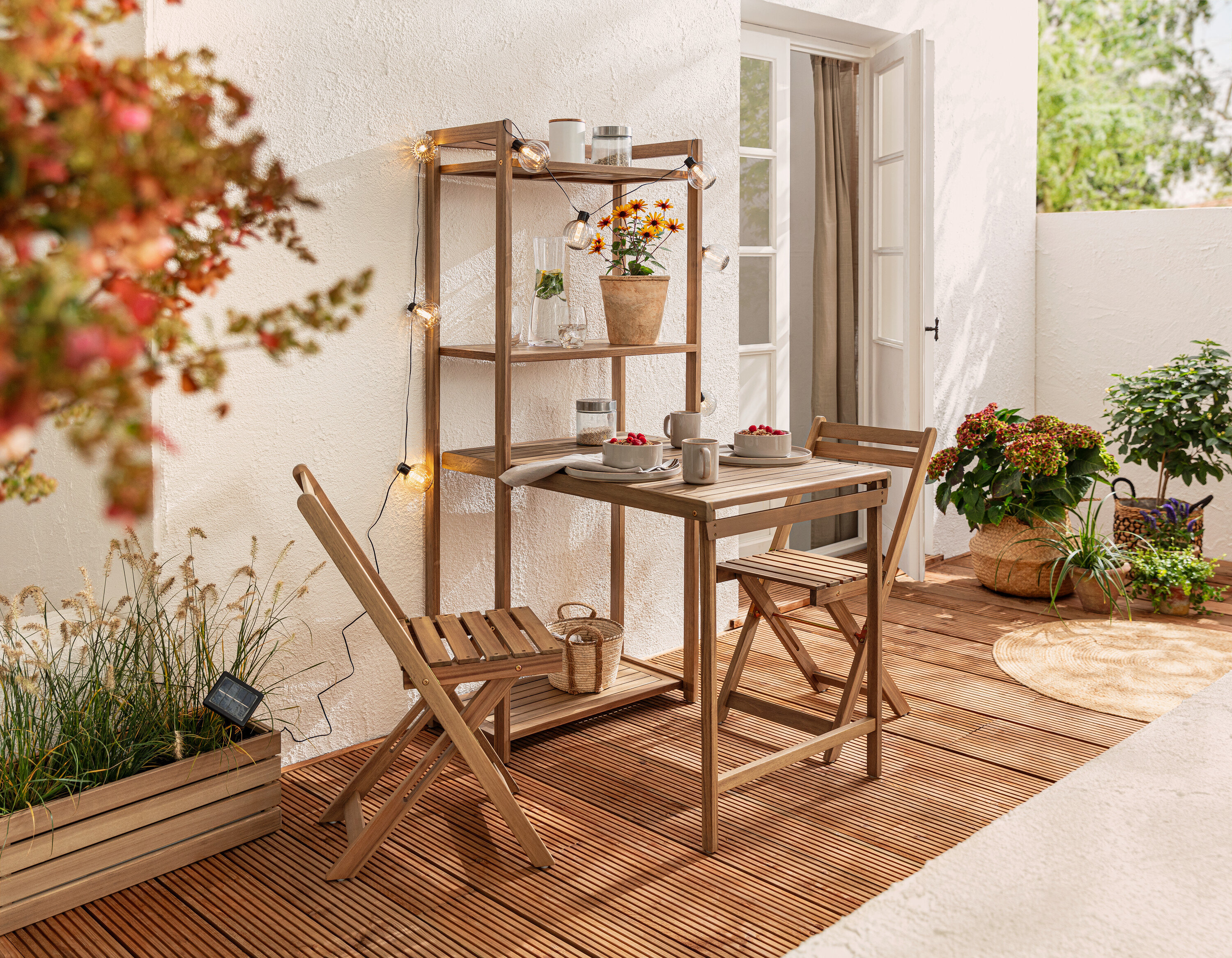 Balkónová jedálenská súprava »Lenja« s regálom a solárna svetelná reťaz, gule s drážkami na balkóne.