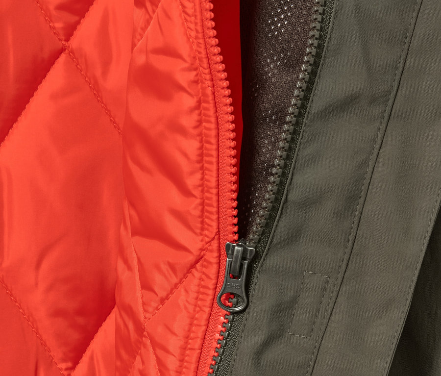 Detail olivového kabáta do dažďa 3 v 1 s oranžovou vestou a zipsom.