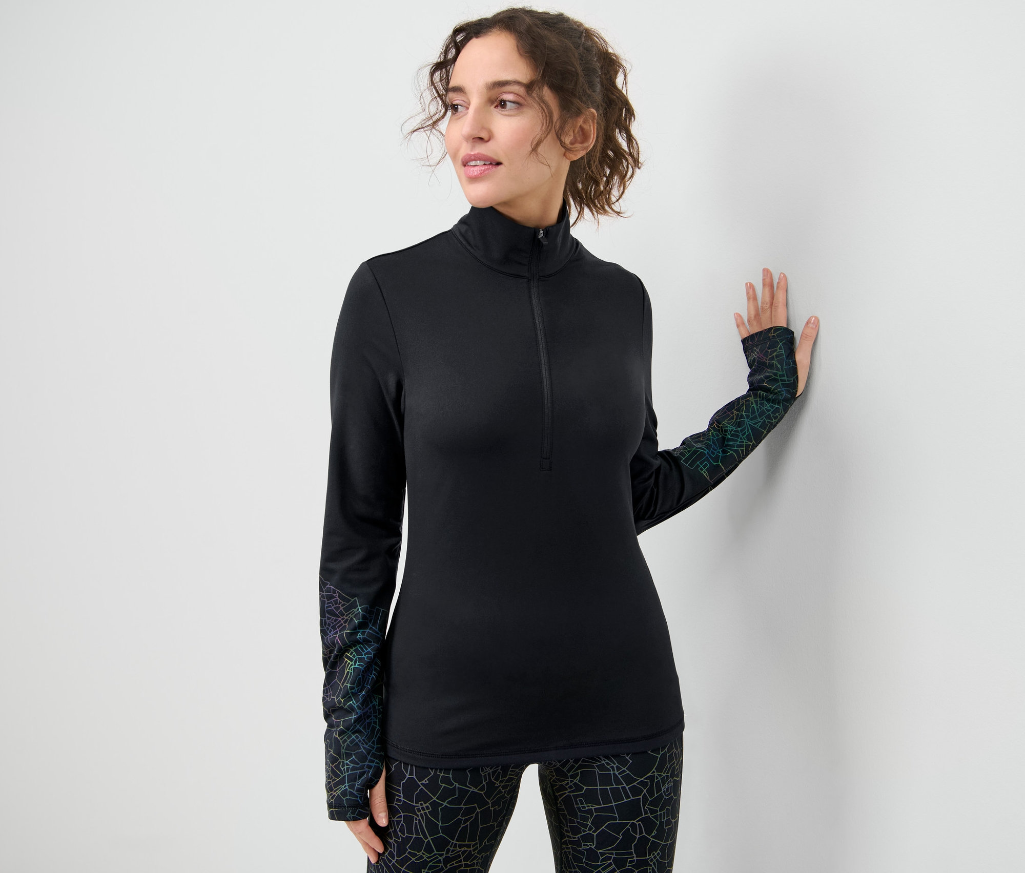 Žena pózuje v čiernom funkčnom termotričku.