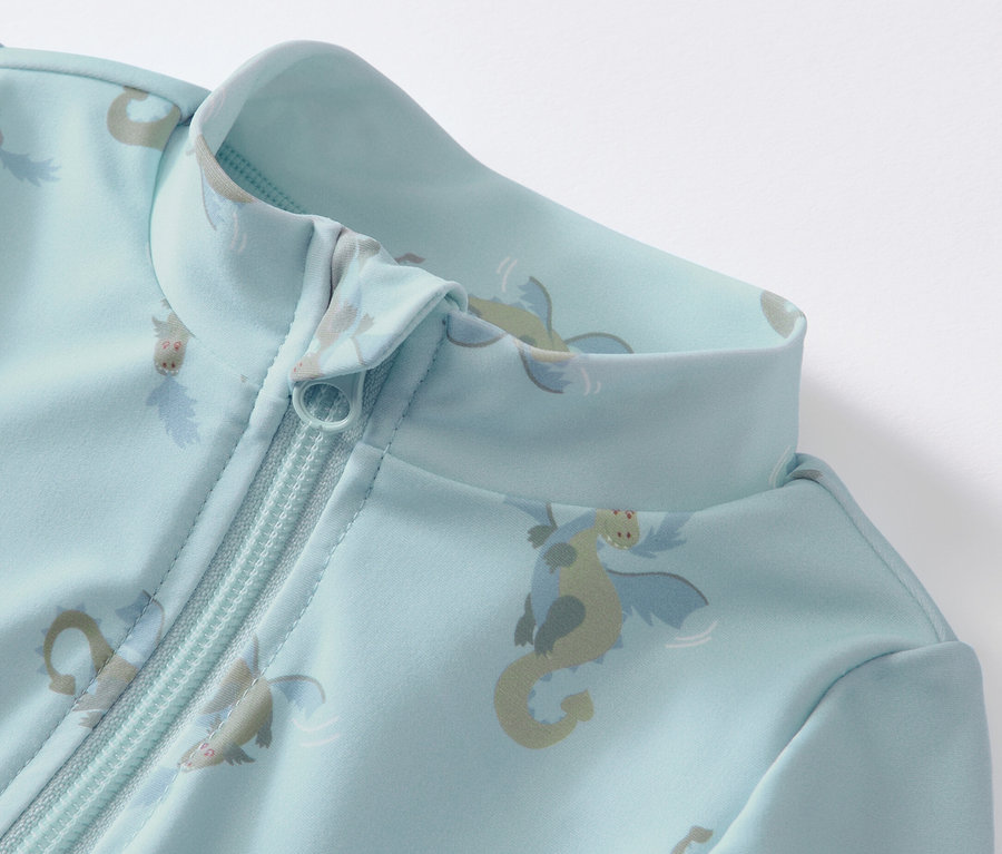 Detail modrého overalu s UV faktorom 80 pre bábätká s potlačou drakov a zipsom.