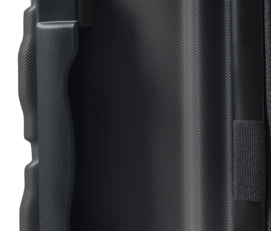 Detail veľkého kufra s tvrdou škrupinou zobrazuje madlo a textúrovaný povrch.