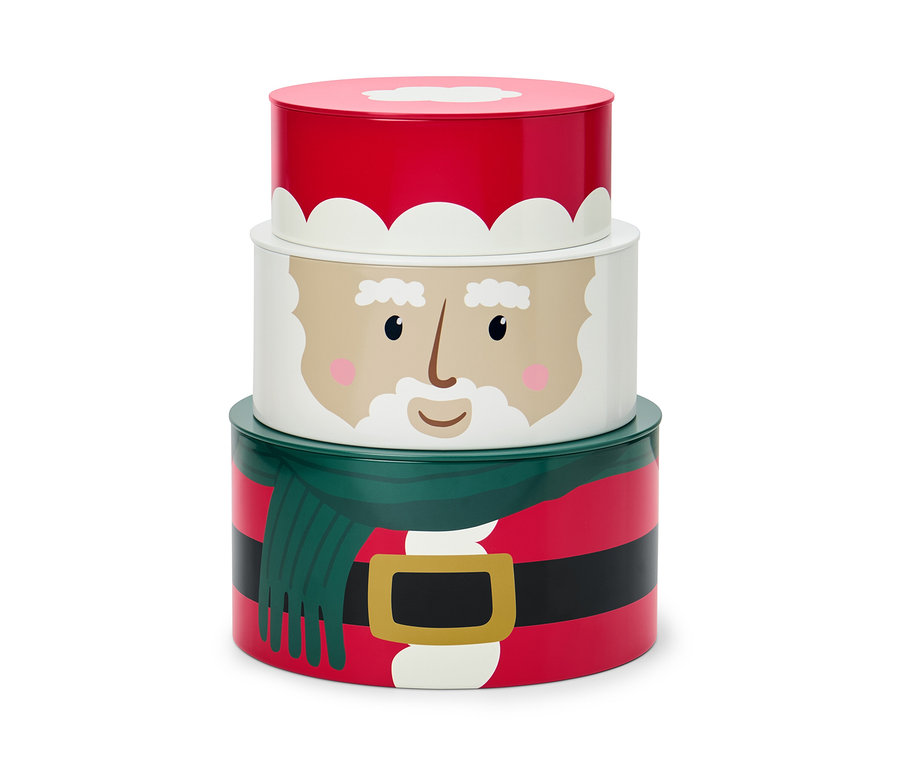 Sada troch dóz na keksy s vianočným motívom, ktoré sú naskladané na sebe.