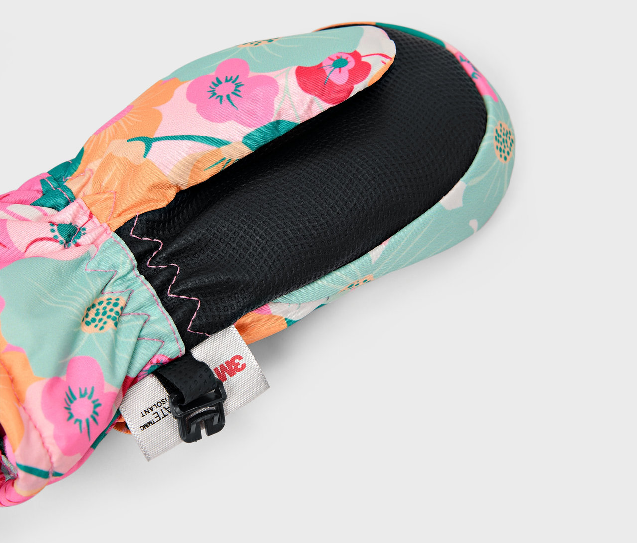 Detail farebnej kvetinovej palčiaky s čiernou vnútornou podšívkou a nastaviteľným popruhom.