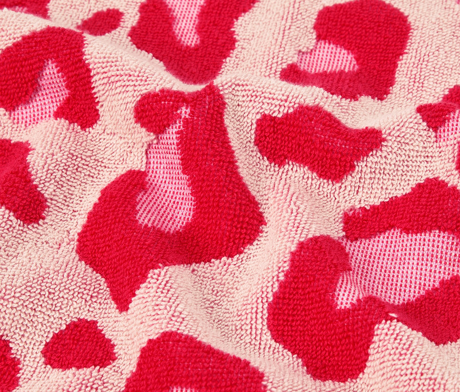 Detailný záber uteráka s ružovým leopardím vzorom.