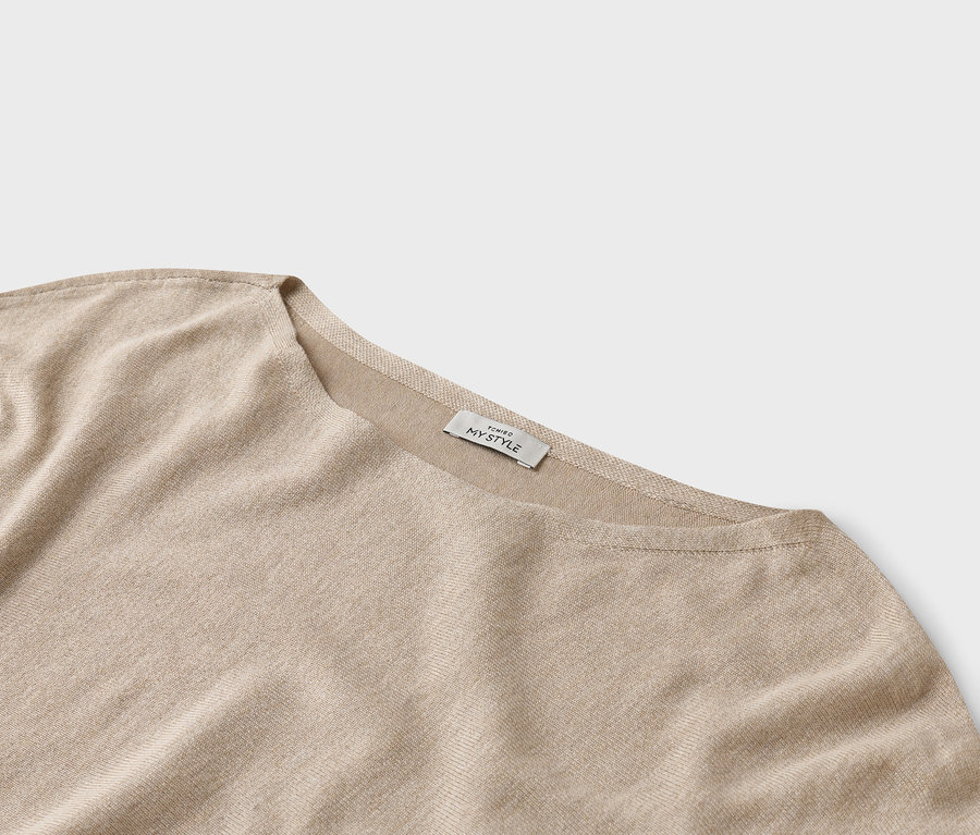 Detailný záber béžového vrchného dielu s etiketou 'TCHIBO MY STYLE'.