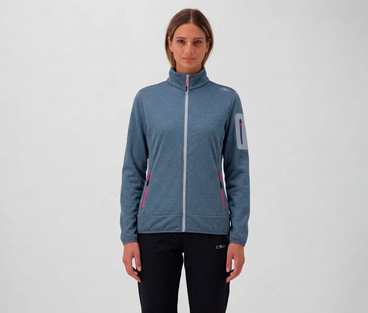 Žena má na sebe modrú melírovanú dámsku bundu CMP so zipsom po celej dĺžke a čierne nohavice na neutrálnom pozadí.