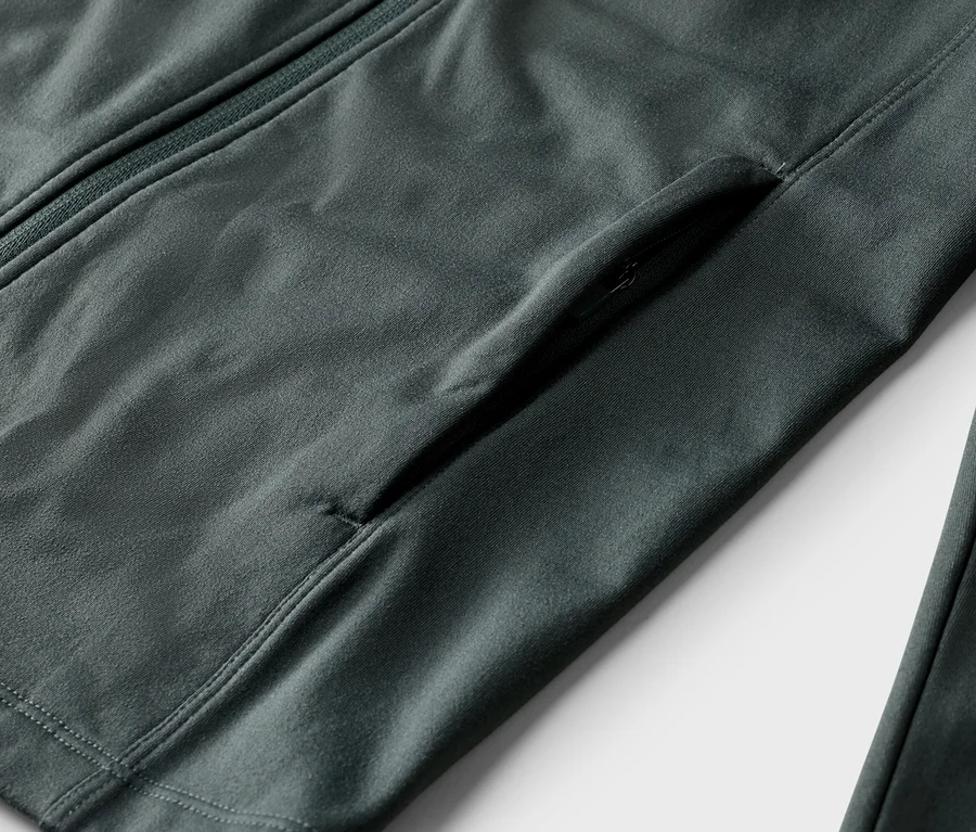 Detail šedej bundy so zipsom a vreckom na zips.