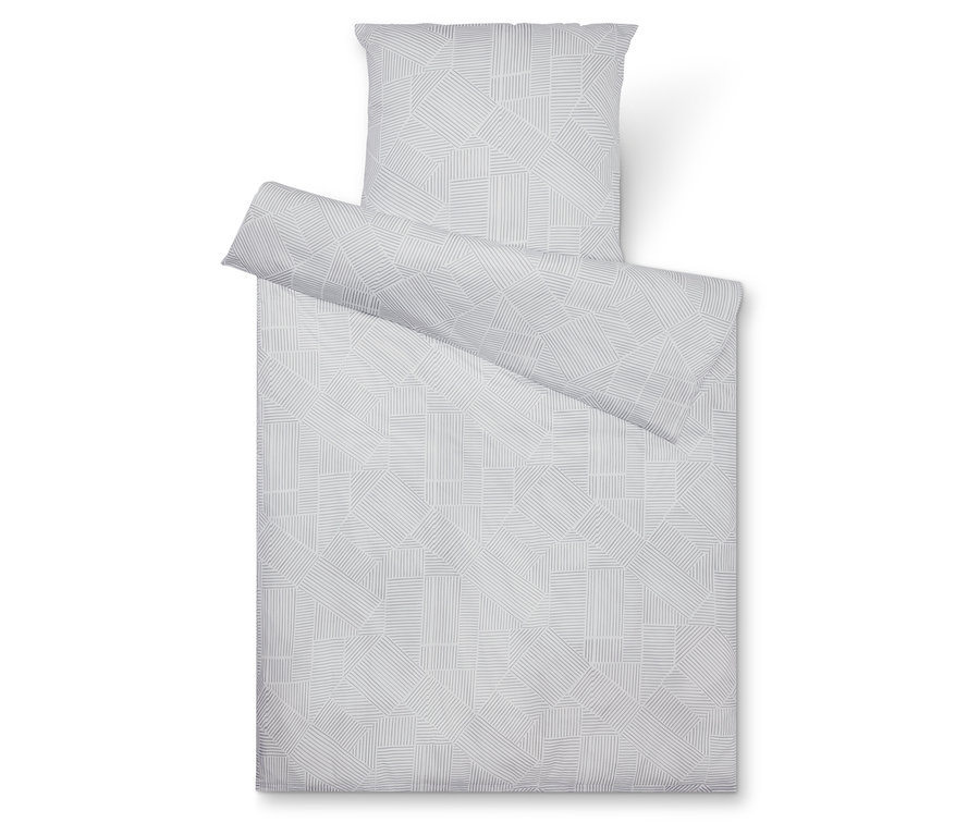 Pohľad zhora na sivú súpravu posteľnej bielizne s geometrickým vzorom, pozostávajúcu z obliečky na vankúš, prikrývky a čiastočne zrolovaného obliečky.