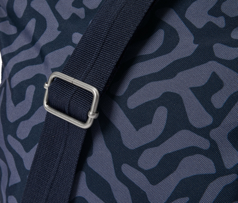 Detail tašky s modrým vzorom a strieborným zapínaním na popruhu.