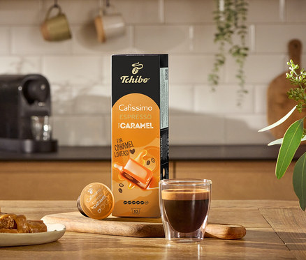 Espresso, karamelky a balenie Edícia Flavoured: Espresso karamel – 80 kapsúl na drevenom stole.