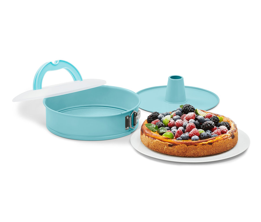 Tyrkysová tortová forma s vekom vedľa torty s ovocím.