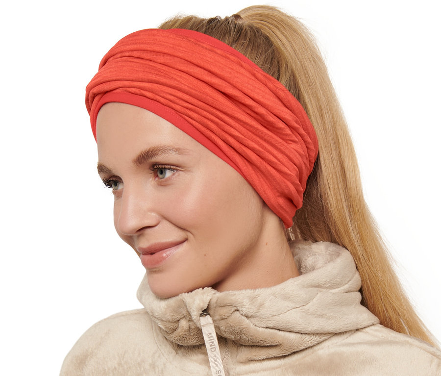 Žena nosí oranžovú multifunkčnú šatku.