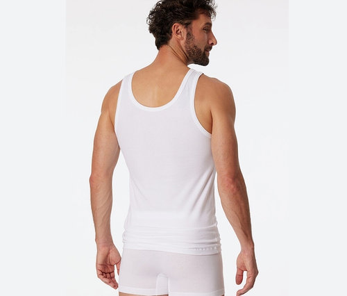 Muž chrbtom k fotoaparátu má na sebe biele tielko SCHIESSER s biobavlnou.