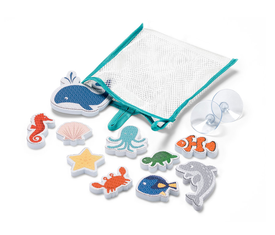 Sada 10 hracích figúrok do vane Morské zvieratá leží vedľa bielej sieťovej tašky s tyrkysovým lemom a dvoma priehľadnými prísavkami.