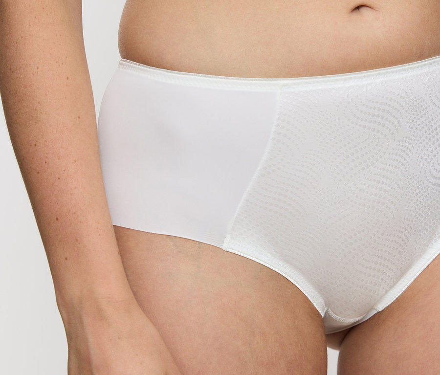 Torzo ženy nosí vanilkové nohavičky Triumph Essential »Minimizer Hipster X«.