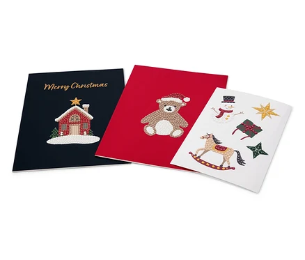 Tri vianočné pohľadnice: tmavomodrá s domom a nápisom Merry Christmas, červená s medveďom a biela s hojdacím koníkom, snehuliakom, darčekom a hviezdami.