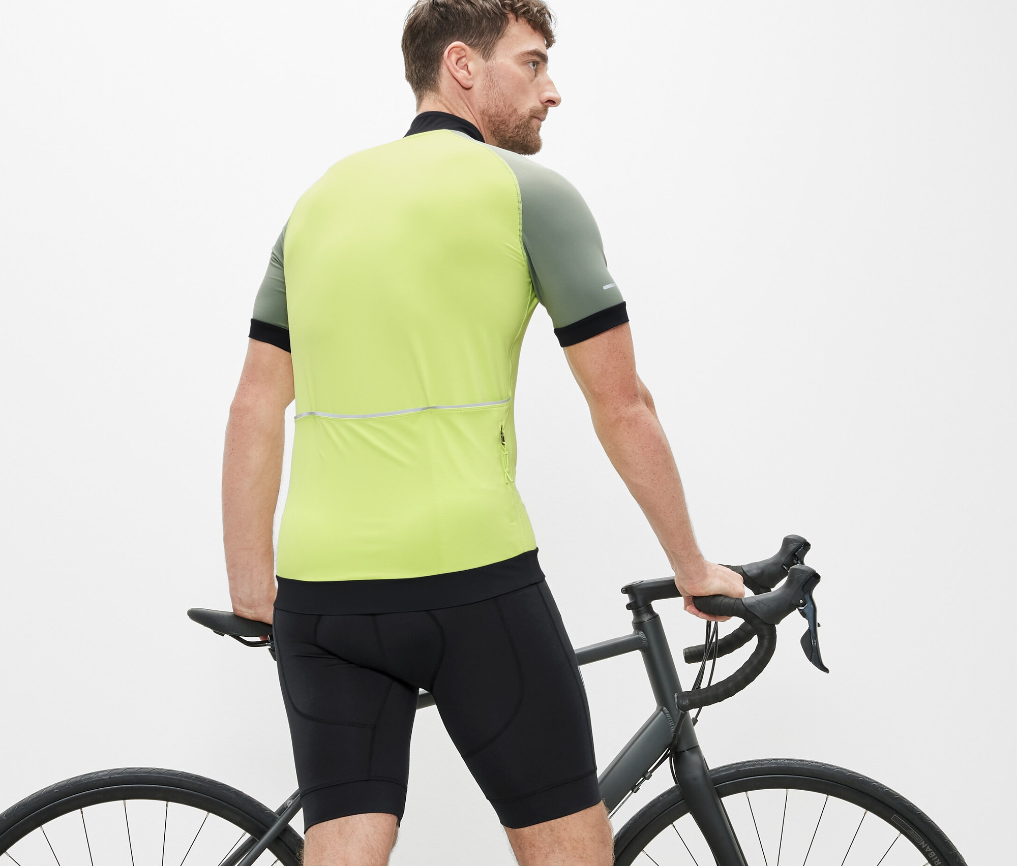 Muž stojí pri bicykli a má na sebe cyklistické nohavice.