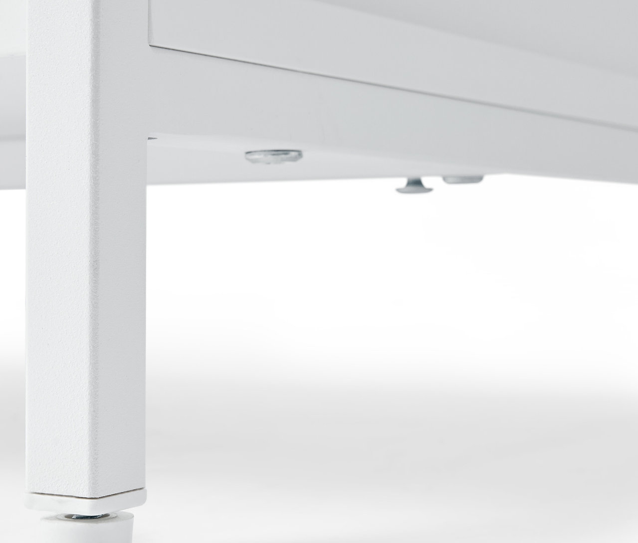 Detail bielej komody »KLAAR« so 4 zásuvkami, pohľad zdola na nohy.