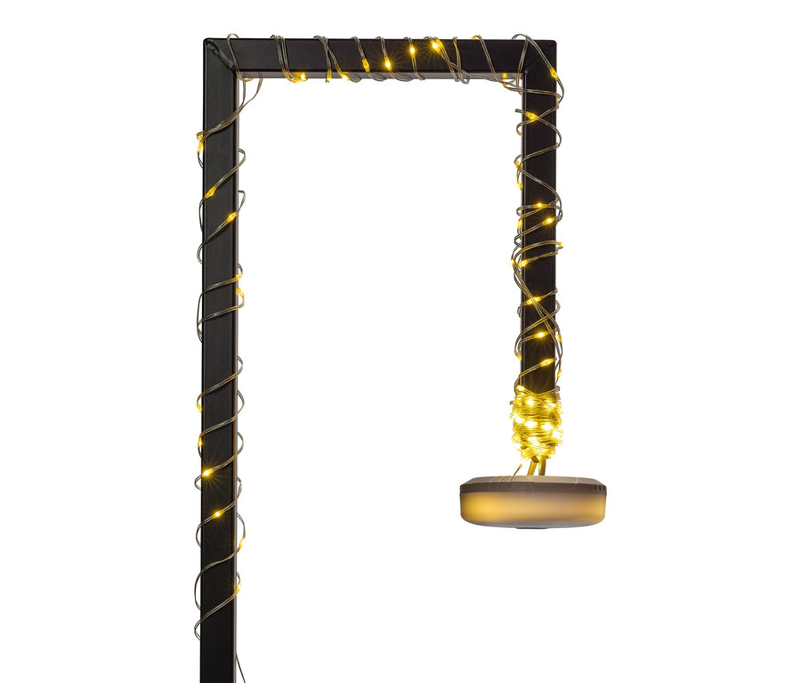 Čierna, obdĺžniková stojaca lampa je obalená teplými bielymi svetelnými reťazami.