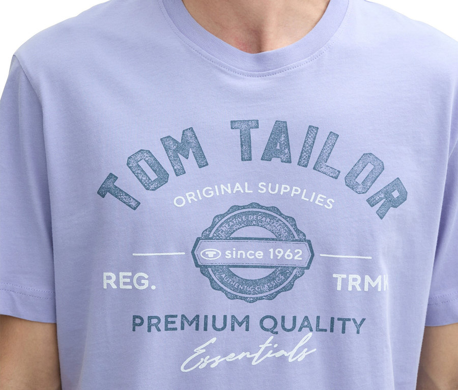 Detail muža v svetlofialovom tričku s potlačou "Tom Tailor".