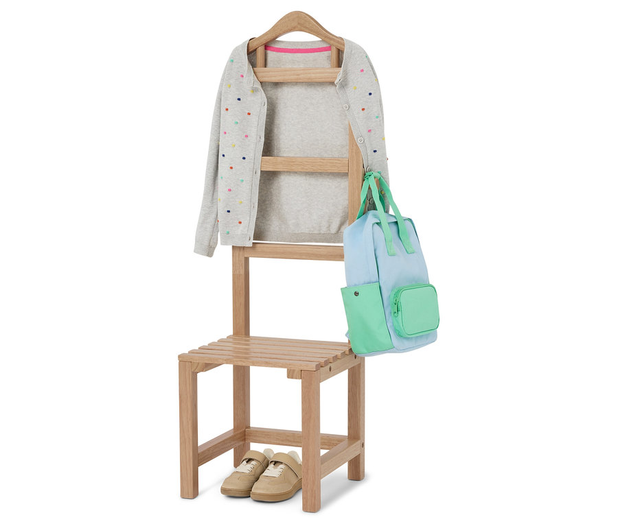 Na stoličke visí sivý kardigán s farebnými bodkami a svetlomodrá a zelená taška. Pod stoličkou sú béžové topánky.