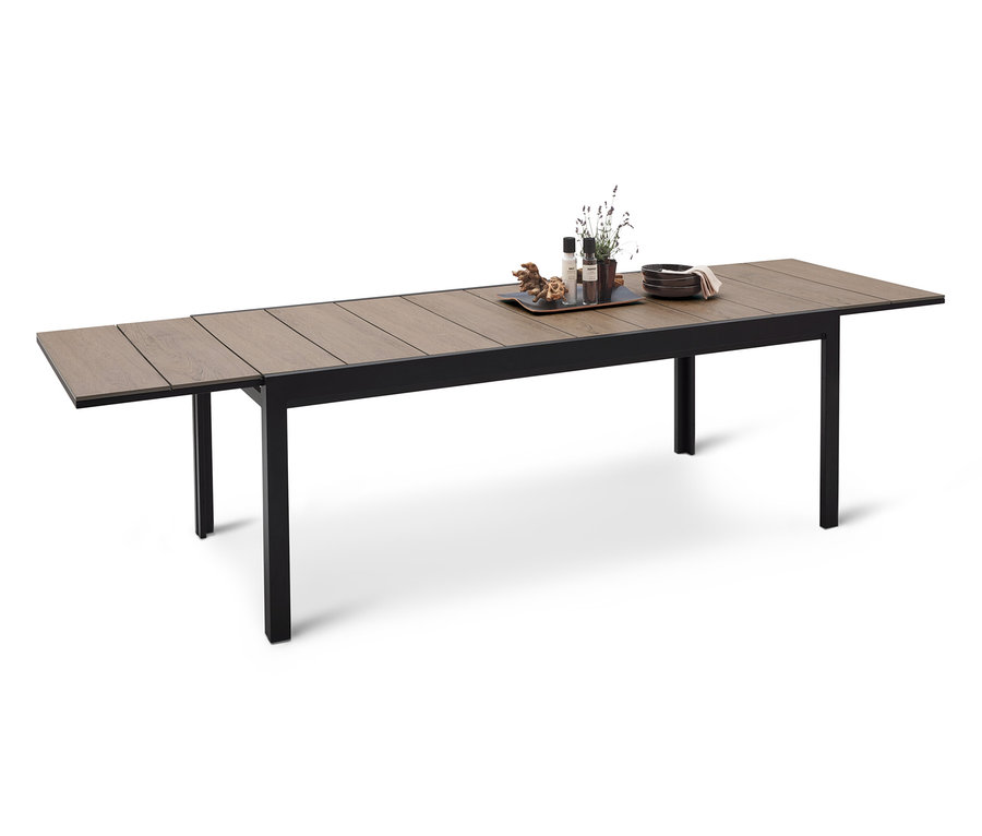 Dlhý jedálenský stôl s čiernym rámom a drevenou doskou, na ktorej je tácka s dekoráciami.