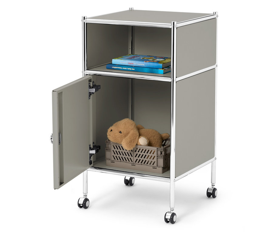 Sivý kontajner na kolieskach s otvorenou priehradkou navrchu s dvoma knihami a otvorenou priehradkou naspodu s plyšovým medvedíkom v sivom boxe.