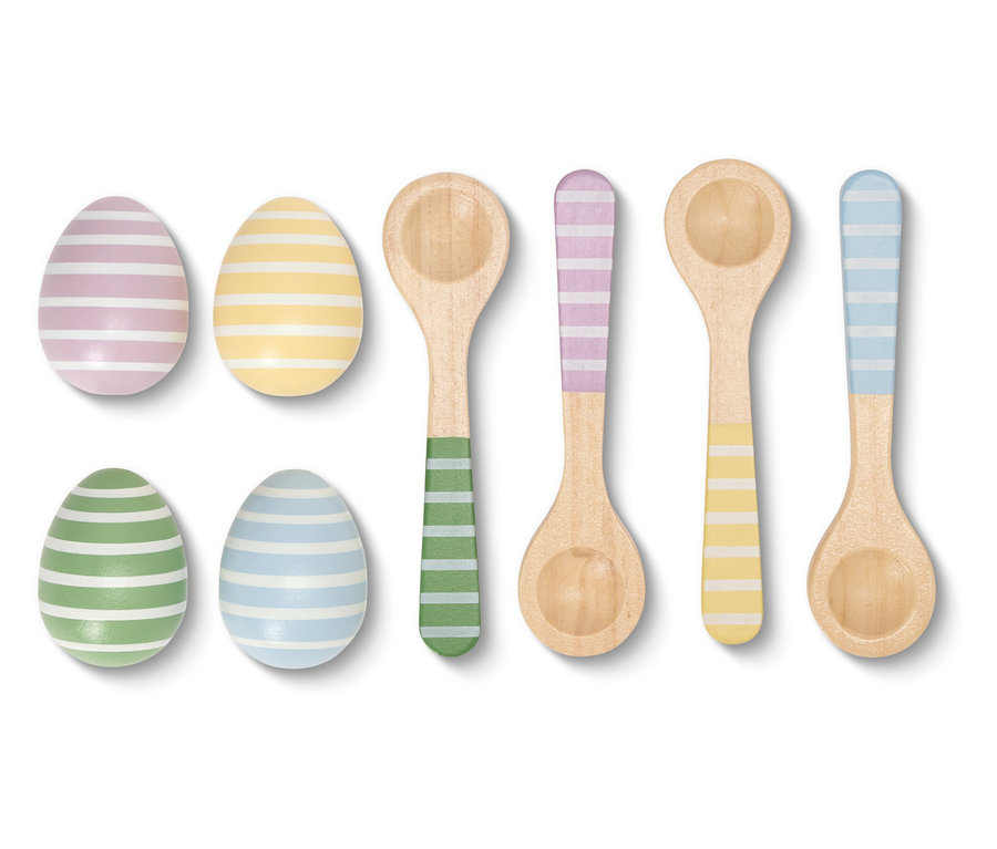 Detailný záber na prúžkované kraslice a farebne zladené drevené lyžice na bielom pozadí.