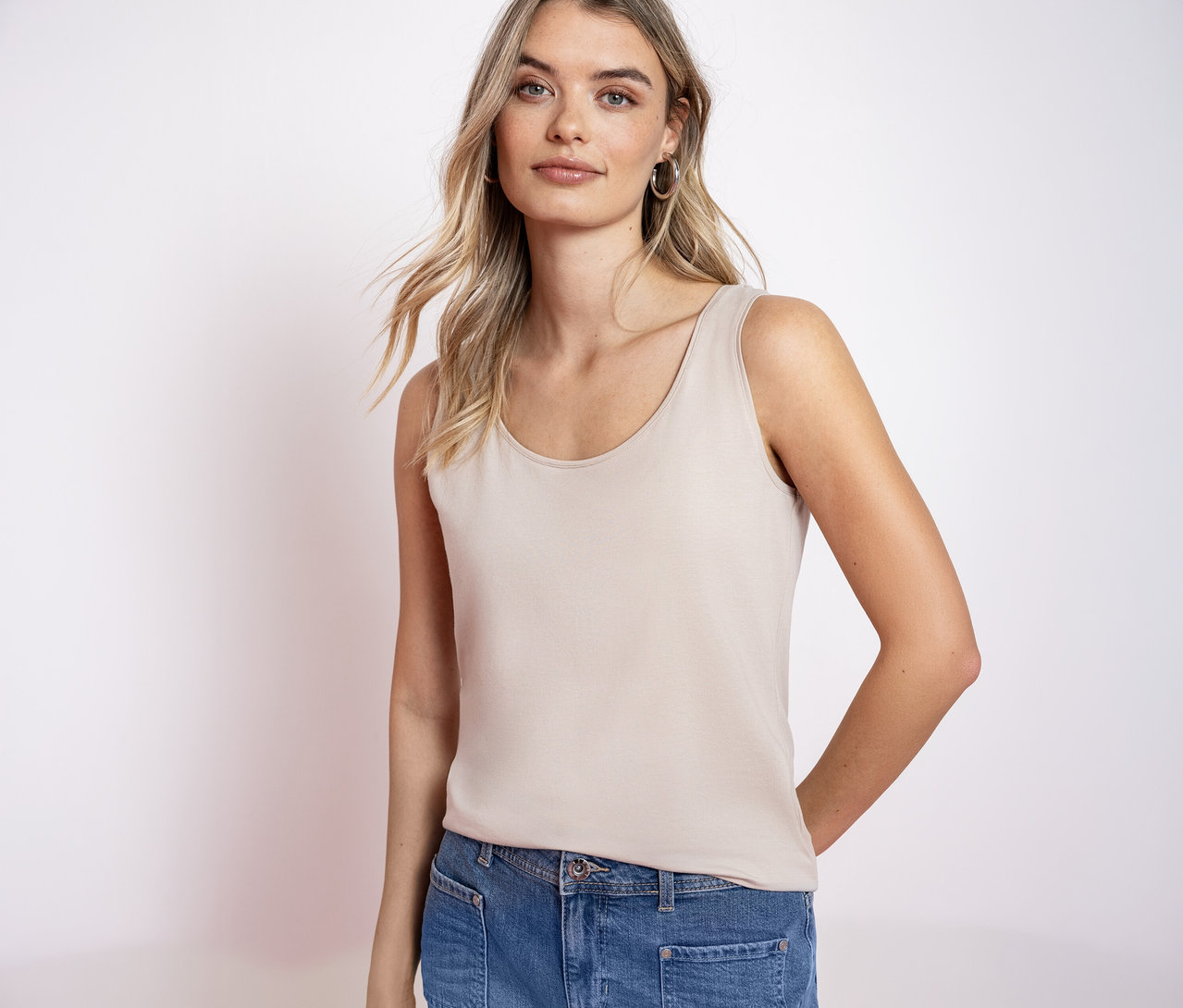 Žena s blond vlasmi má na sebe základný top Street One a džínsy.