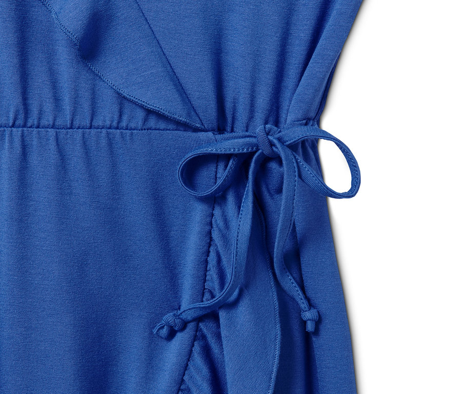 Detail modrých džersejových šiat v zavinovacom vzhľade so zaväzovaním v páse.