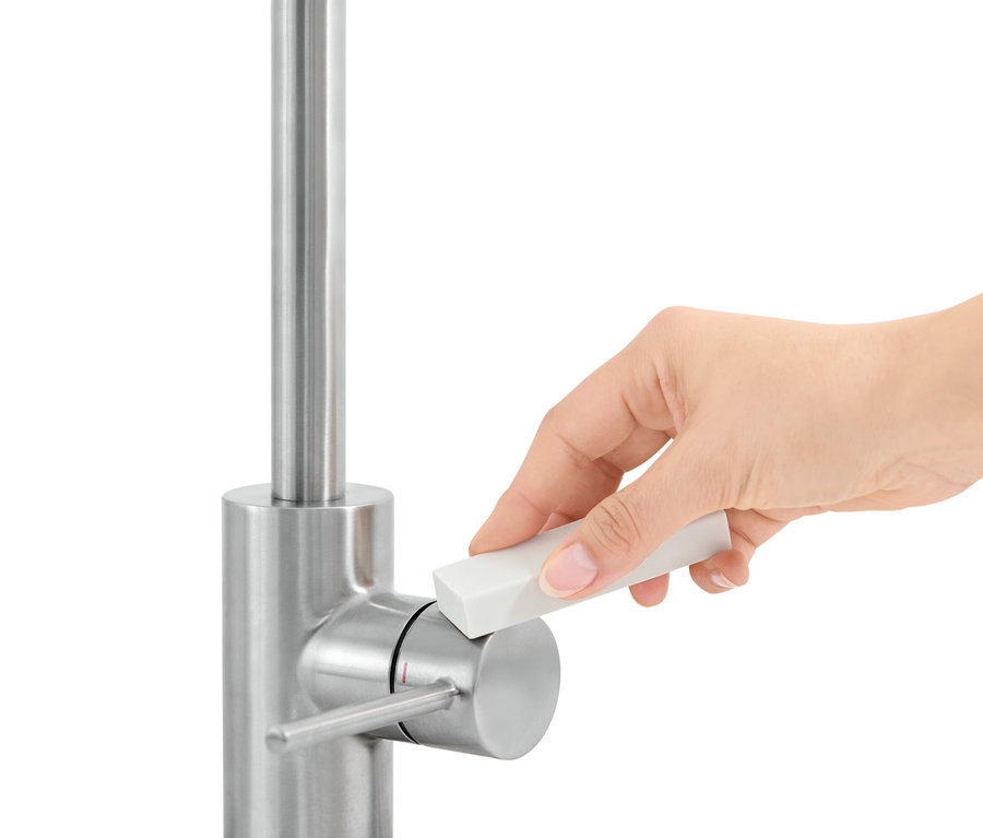 Ruka používa odstraňovač vodného kameňa (2 ks) na kohútiku.