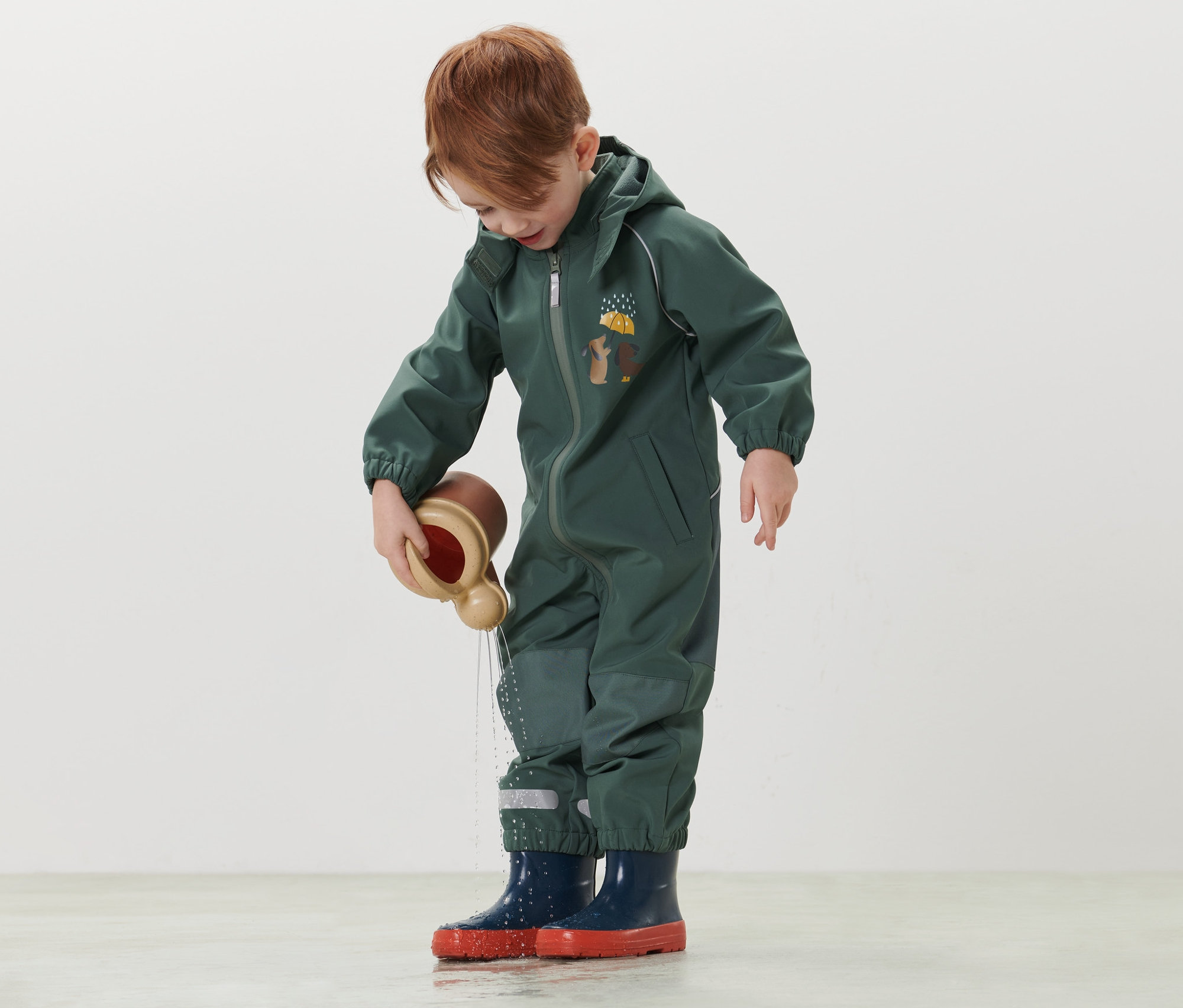 Chlapec sa hrá s hračkou na vodu v detskom softshellovom overale.