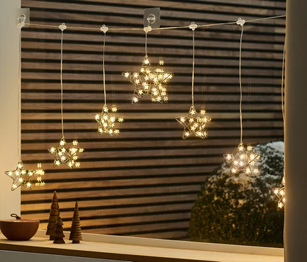 Svetelný LED záves v tvare hviezdy visí na okne.