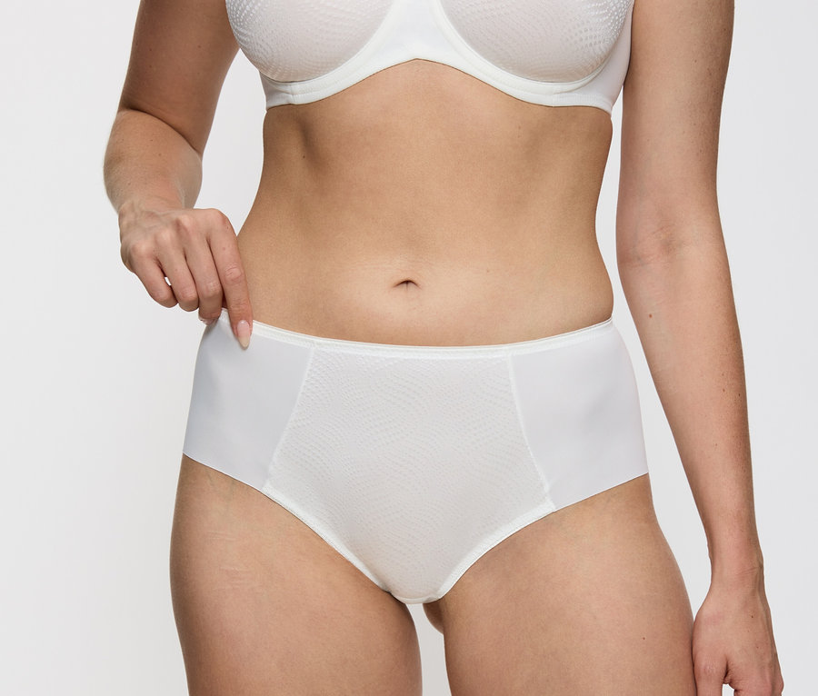 Žena má na sebe vanilkové nohavičky Triumph Essential »Minimizer Hipster X«.